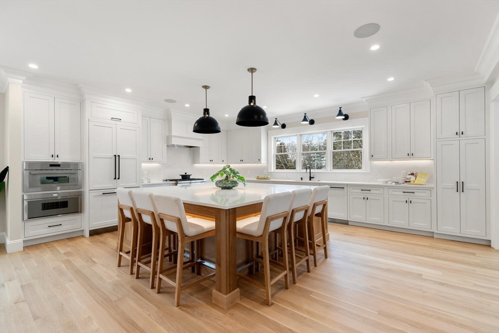 2 Abby Road Winchester, MA 01890 - Photo 12 of 42 a kitchen with stainless steel appliances kitchen island granite countertop a table chairs and a refrigerator