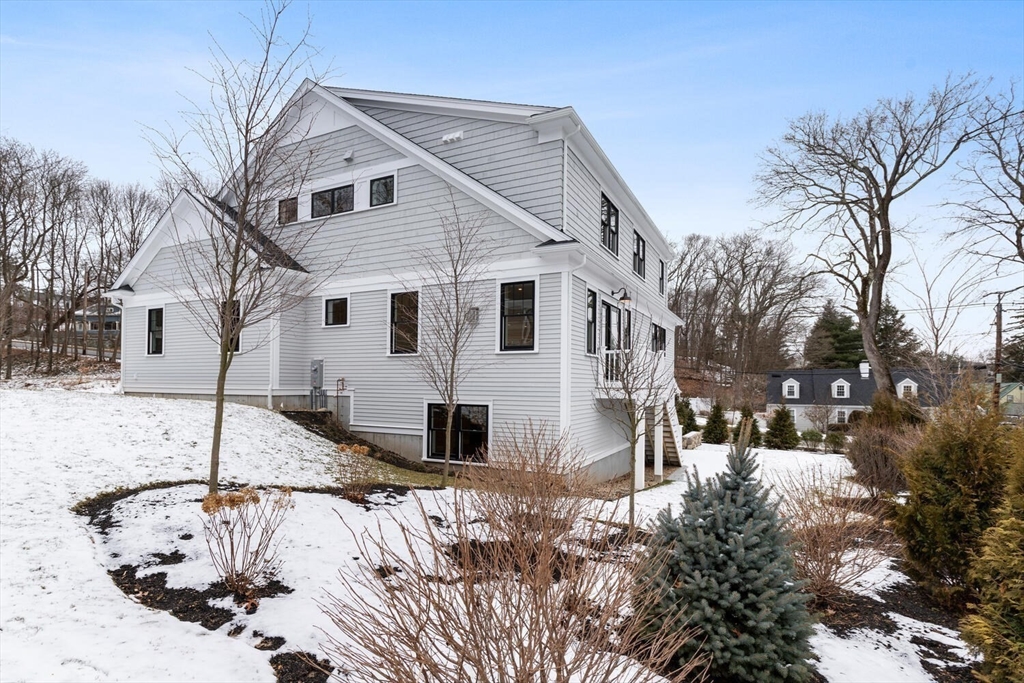 2 Abby Road Winchester, MA 01890 - Photo 36 of 42 a view of a white house with a yard covered in snow