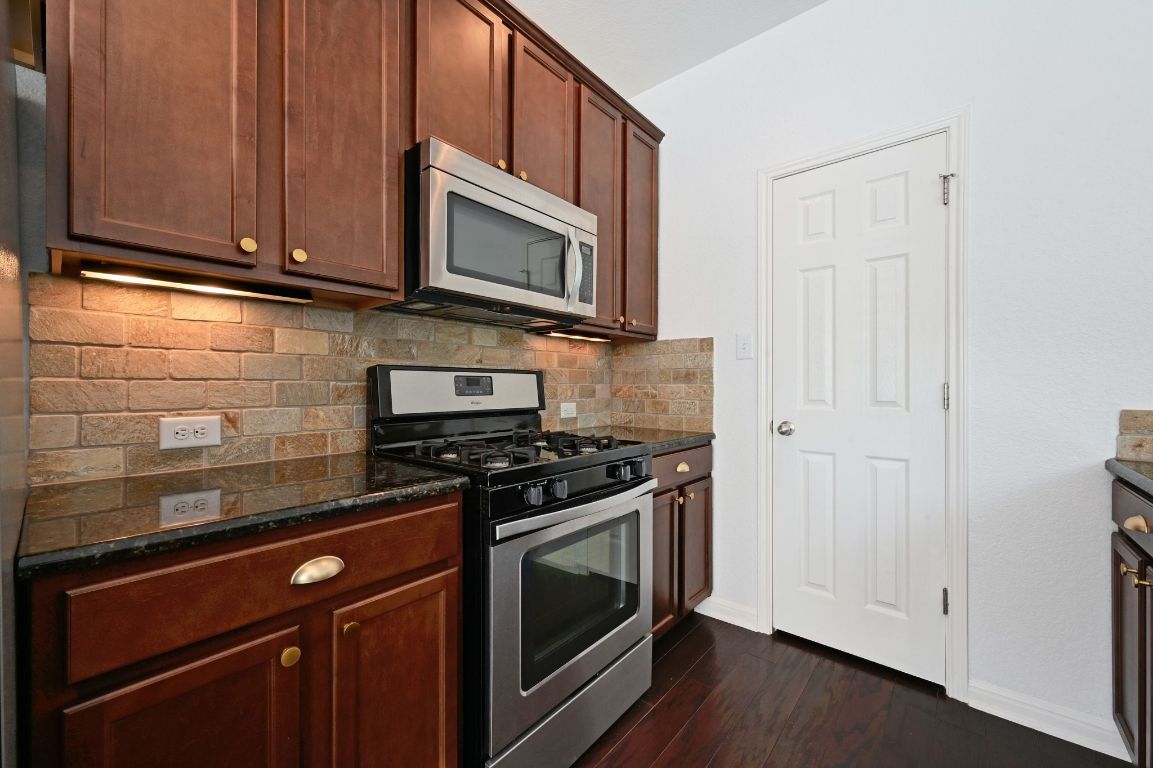 11248 Lost Maples Trail, Unit 11248 Austin, TX 78748 - Photo 11 of 22 a kitchen with stainless steel appliances granite countertop a stove microwave and oven