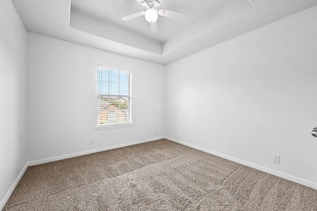 an empty room with a window and a ceiling fan