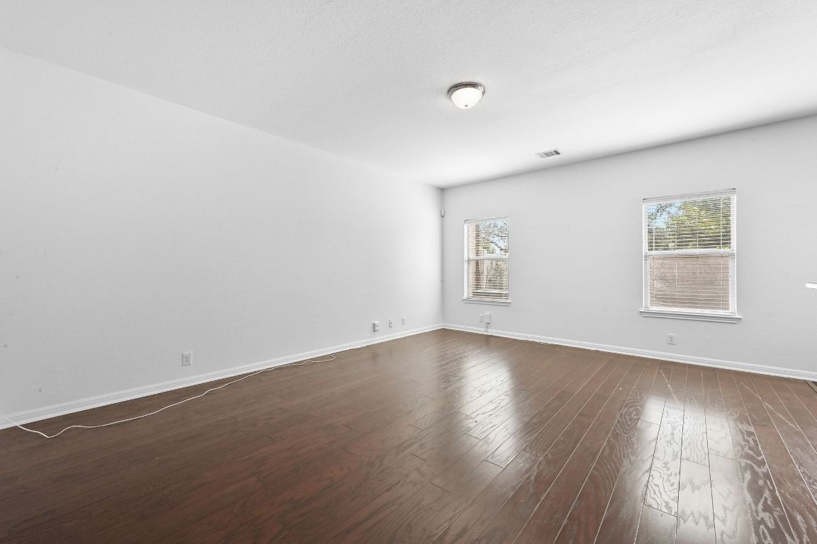 11248 Lost Maples Trail, Unit 11248 Austin, TX 78748 - Photo 5 of 22 an empty room with wooden floor and windows