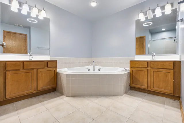 a spacious bathroom with a tub sink and mirror