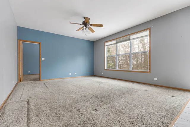 en empty room with windows and ceiling fan