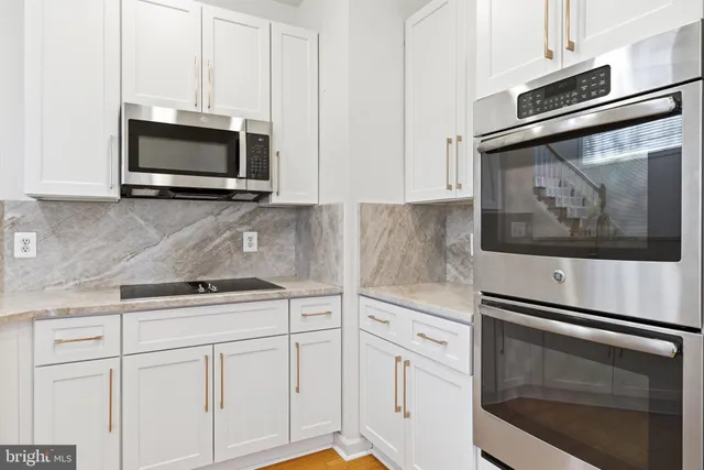 a kitchen with white cabinets stainless steel appliances and sink