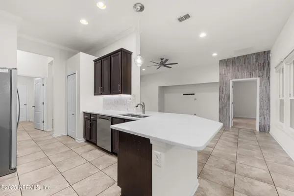 a large white kitchen with a stove a refrigerator a sink and dishwasher