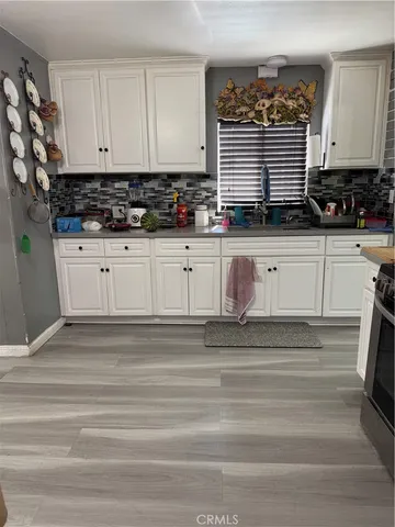 a kitchen with granite countertop white cabinets and white appliances