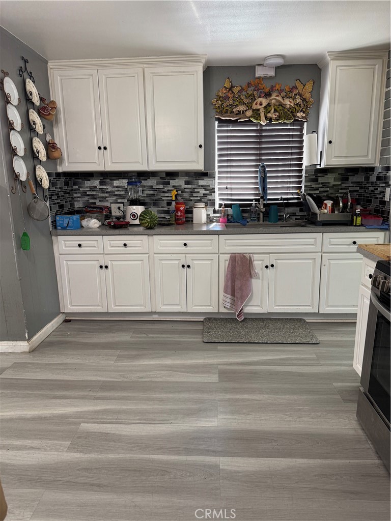 854 North 9th Street Colton, CA 92324 - Photo 9 of 36 a kitchen with granite countertop white cabinets and white appliances