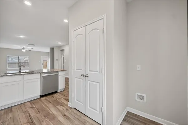 a kitchen with a refrigerator and white cabinets