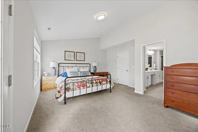 a bedroom with a bed a window and dresser