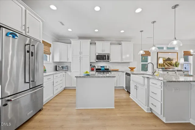 a kitchen with white cabinets and stainless steel appliances
