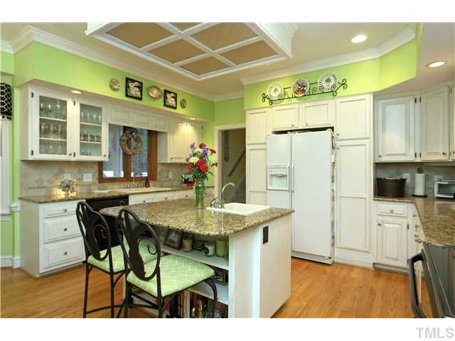 2104 Countrywood Road North Raleigh, NC 27615 - Photo 13 of 25 a kitchen with stainless steel appliances kitchen island granite countertop a table chairs and a refrigerator