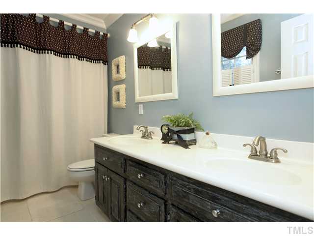 2104 Countrywood Road North Raleigh, NC 27615 - Photo 17 of 25 a bathroom with a sink and a mirror