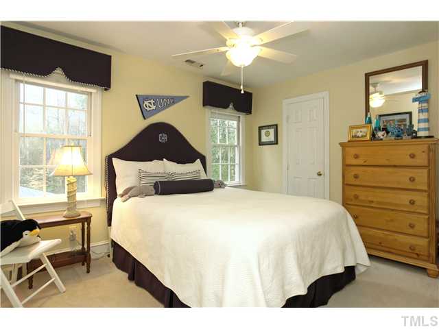 2104 Countrywood Road North Raleigh, NC 27615 - Photo 19 of 25 a bedroom with a bed and a chandelier