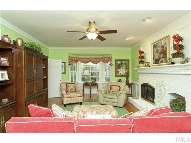 2104 Countrywood Road North Raleigh, NC 27615 - Photo 8 of 25 a living room with furniture a fireplace and a chandelier