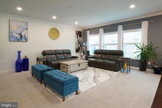 a living room with furniture kitchen view and a large window