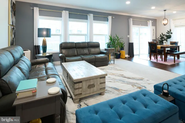 a kitchen with kitchen island granite countertop a sink a counter top space and living room view