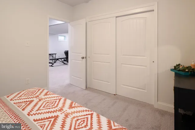 a bedroom with a bed a desk and chair with a bookshelf