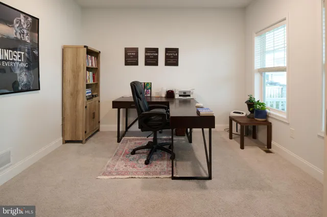 a view of a workspace with furniture and a window