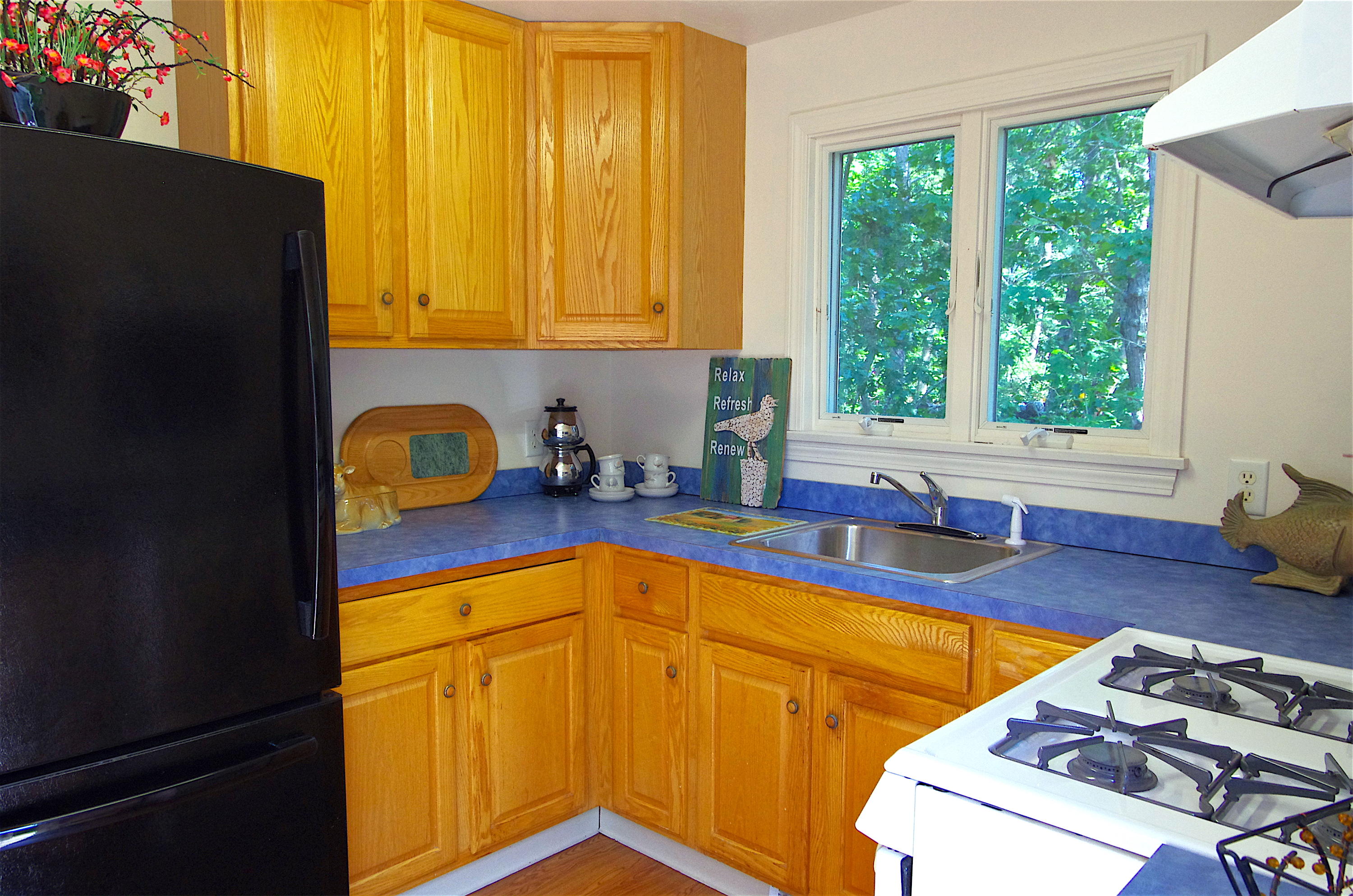 10 Juniper Way Eastham, MA 02642 - Photo 5 of 31 a kitchen with stainless steel appliances granite countertop a refrigerator a sink dishwasher stove and wooden cabinets with wooden floor