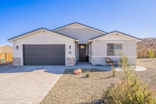 a front view of a house with a yard outdoor seating and garage