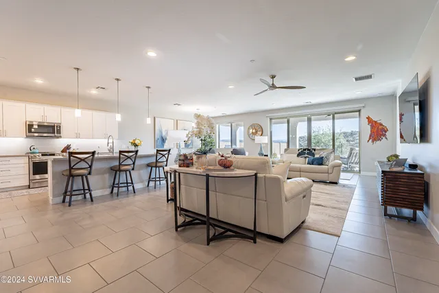 a living room with furniture a window and a potted plant