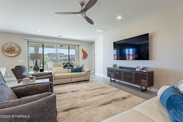 a living room with furniture a flat screen tv and a large window