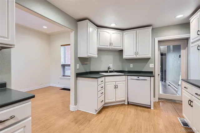 a kitchen with granite countertop white cabinets and white appliances