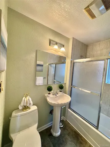 a bathroom with a sink mirror and toilet