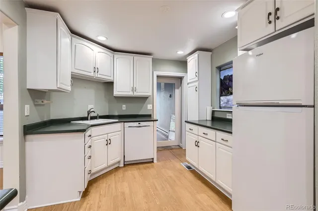 a kitchen with granite countertop a sink stove and refrigerator