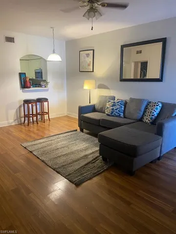 a living room with furniture and a wooden floor