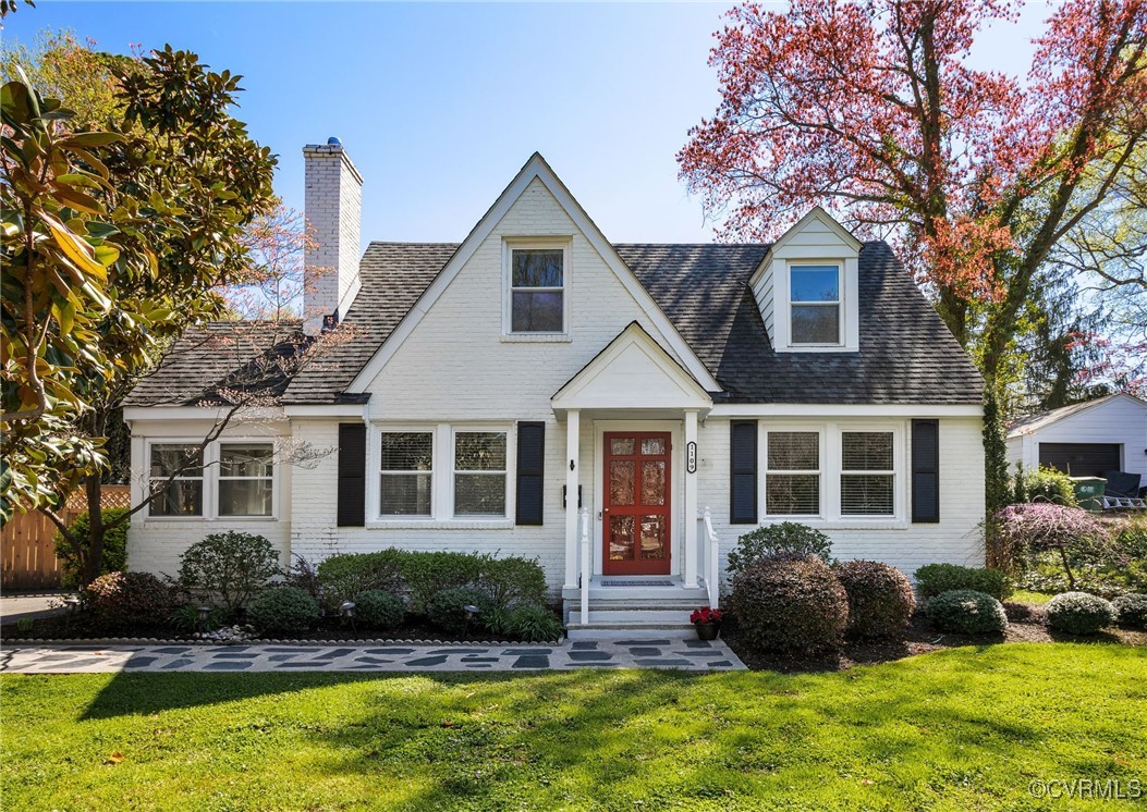 a front view of a house with a yard and potted plants