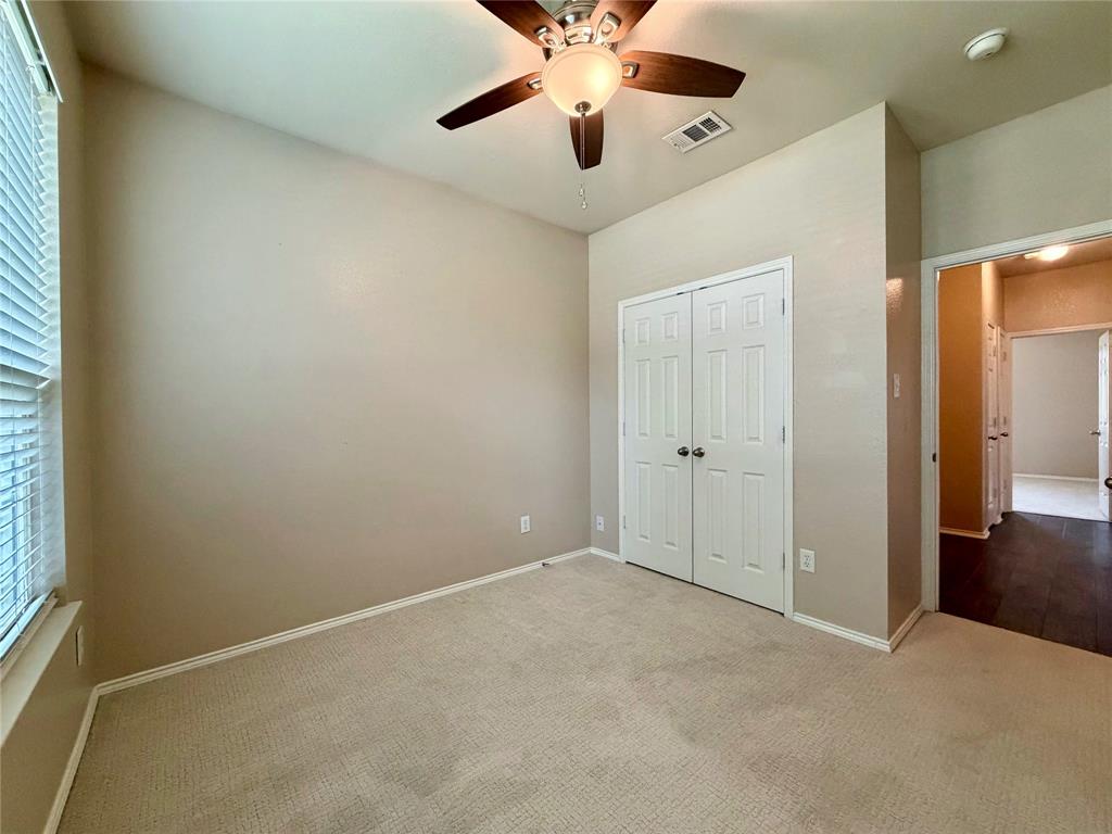 5817 Deck House Road Fort Worth, TX 76179 - Photo 14 of 19 Carpeted room featuring a ceiling fan with integrated lighting, a window with blinds, and white bi-fold closet doors