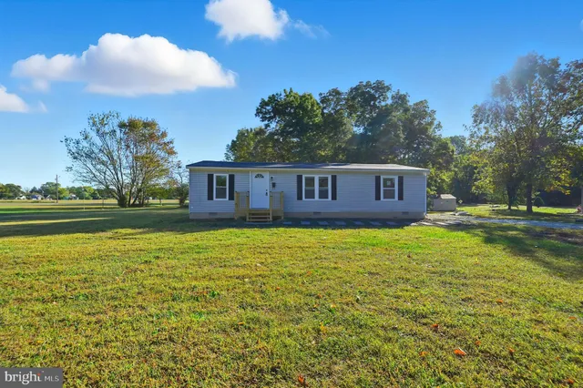 a view of a big house with a big yard and large trees