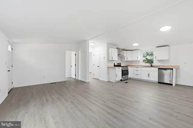 a view of a kitchen with wooden floor and appliances