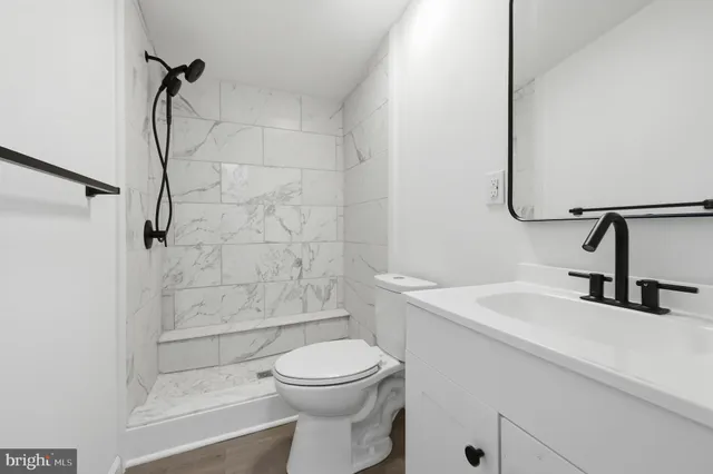 a bathroom with a sink a toilet and shower