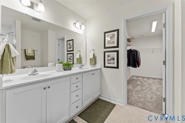 a spacious bathroom with a double vanity sink and mirror
