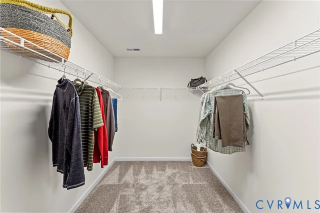 a view of walk in closet with clothes and shoes