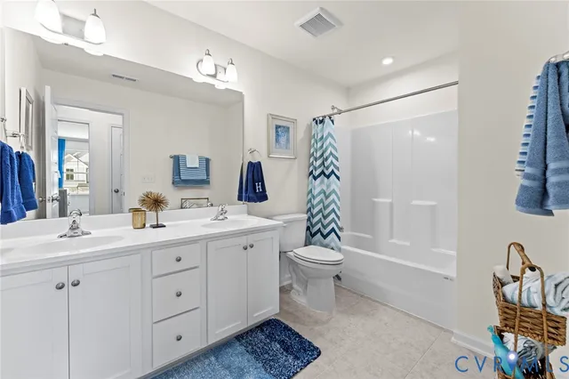 a bathroom with a double vanity sink toilet and shower