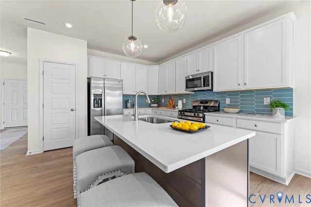 a kitchen with stainless steel appliances granite countertop a sink refrigerator and microwave