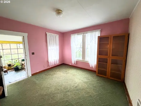 a view of empty room with window and wooden floor
