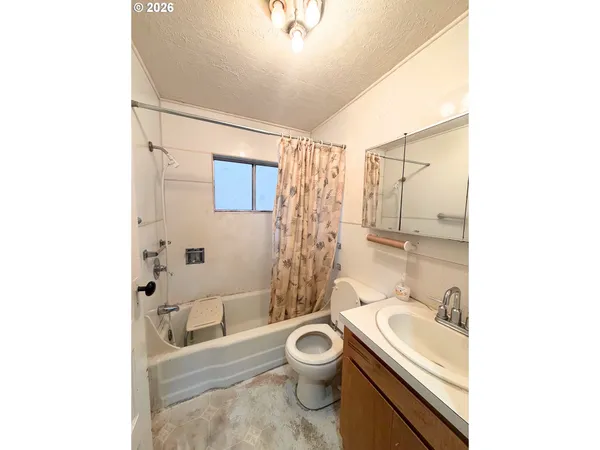 a bathroom with a granite countertop toilet a sink and a mirror