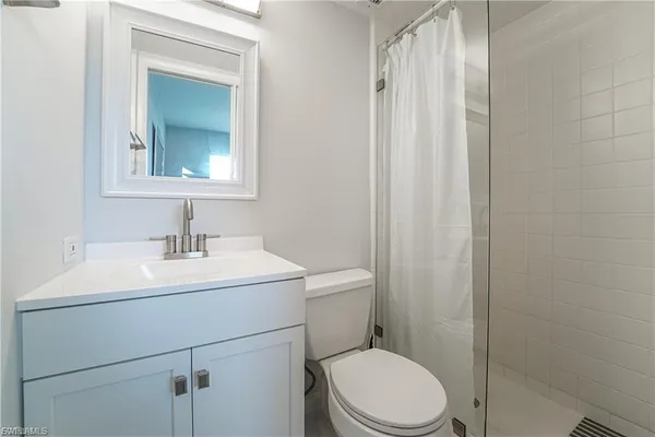 a bathroom with a toilet sink vanity and mirror