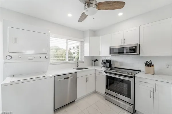 a kitchen with white cabinets stainless steel appliances and sink