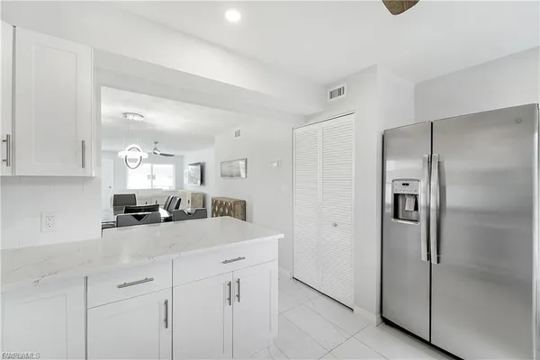 a kitchen with white cabinets and stainless steel appliances