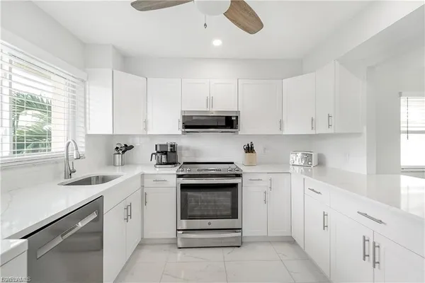 a kitchen with a sink stove and microwave