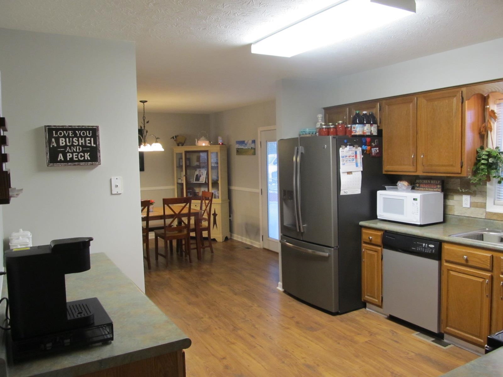 2118 Knightly Mill Road Fort Defiance, VA 24437 - Photo 21 of 49 a kitchen with stainless steel appliances granite countertop a refrigerator a stove a sink a dining table and chairs with wooden floor