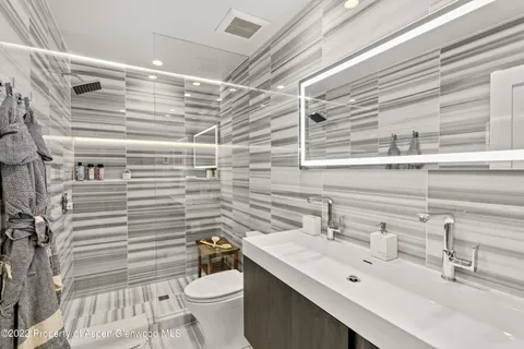 a bathroom with a sink mirror vanity and toilet
