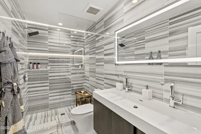 a bathroom with a sink mirror vanity and toilet