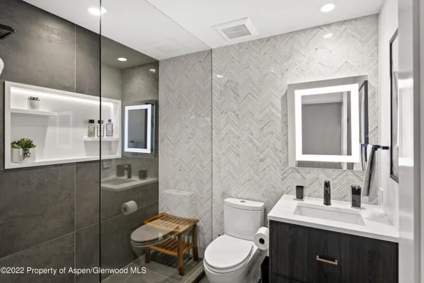 a bathroom with a toilet sink vanity and mirror