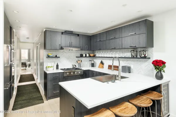 a kitchen with a sink a stove and chairs